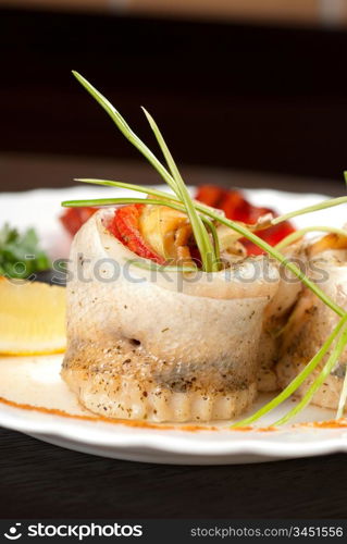 fillet of pikeperch stuffed with trout fish with baked pepper, tomato and leek