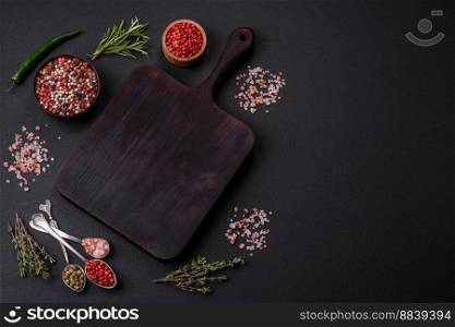 Fillet of raw red salmon fish with salt, spices and herbs on a dark concrete background