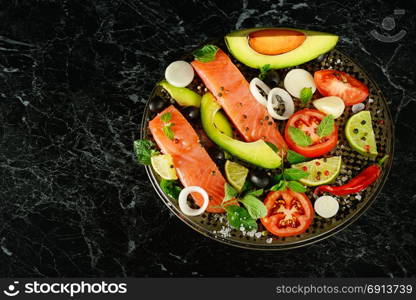 Fillet of red fish and spices on a black background. Free space for text.