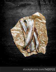 Fillet of salted herring on old paper. Black chalkboard.. Fillet of salted herring on old paper