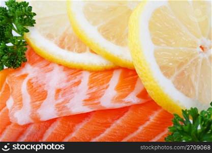 Fillets of fresh salmon with lemon slices on ice. Macro.