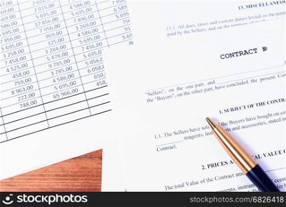Filling business contract in terms of details of the parties. A contract with a lying pen and financial chart on the office Desk