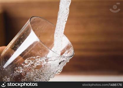 Filling glass of water from stainless steel kitchen faucet. Drinking water concept. Austria pure water from mountains.. Filling glass of water from stainless steel kitchen faucet. Drinking water concept