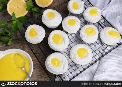 "Filling with a lemon kurd, a delicate, crispy mini-dessert "Pavlova" on the rack"