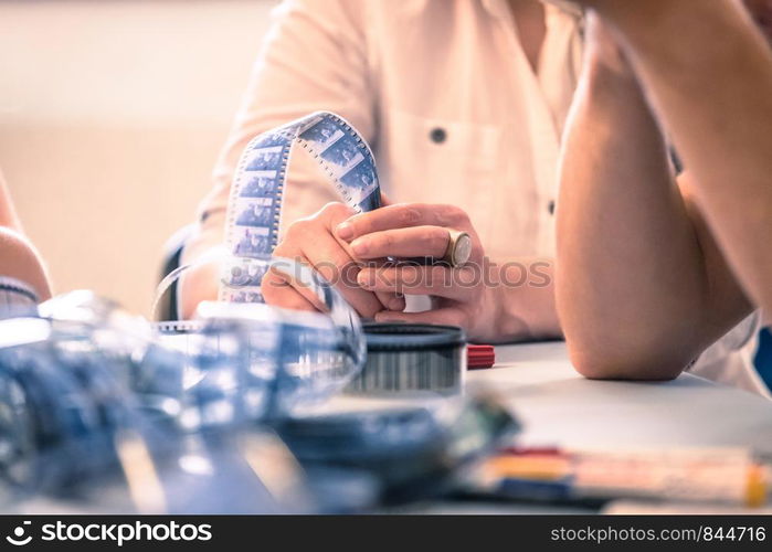 Filmmaker hands holding a film strip, cutting table