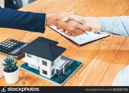 Finalizing house loan agreement with handshake, buyer and real estate agent celebrate accomplishment of property ownership with sense of satisfaction. New home owner shake hand with broker. Entity. Finalizing house loan agreement with handshake in office. Entity