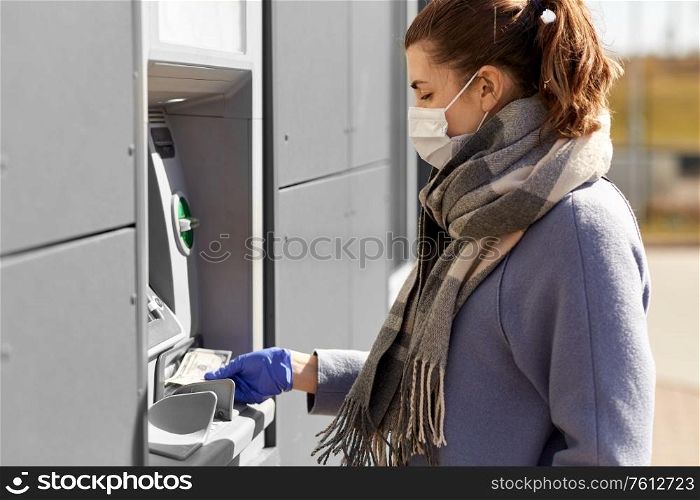 finance, bank and hygiene concept - woman in medical mask and glove with cash money at atm machine. woman in medical mask and glove with money at atm