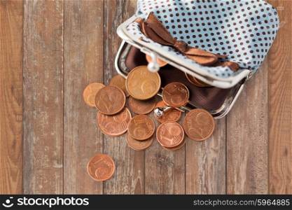finance, cash, money saving and investment concept - close up of euro coins and wallet on wooden table