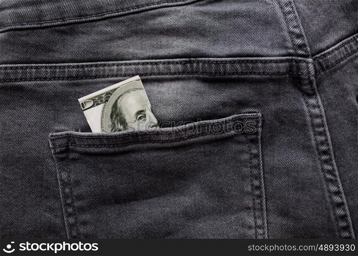 finance, clothes and currency concept - dollar money in back pocket of denims or jeans