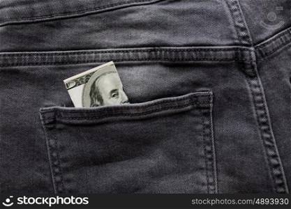 finance, clothes and currency concept - dollar money in back pocket of denims or jeans