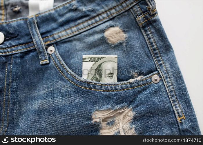 finance, clothes and currency concept - dollar money in pocket of denims or jeans