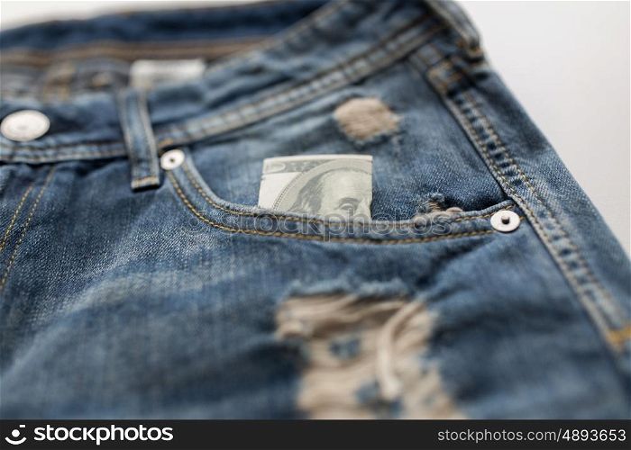 finance, clothes and currency concept - dollar money in pocket of denims or jeans