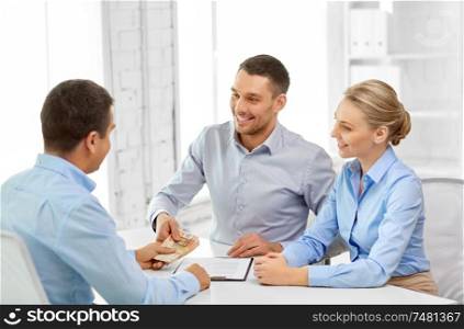finance, corporate and people concept - business people with contract and money at office. business people with contract and money at office