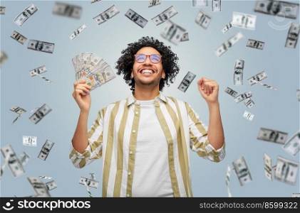 finance, currency and people concept - happy man holding hundreds of dollar money banknotes celebrating success over grey background. happy man with dollar money celebrating success