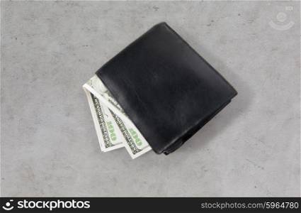 finance, investment, saving and cash concept - close up of dollar money in wallet on gray concrete table