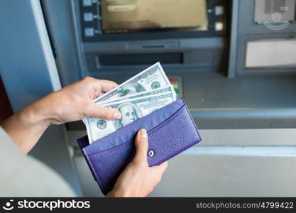 finance, money, bank and people concept - close up of hand with wallet withdrawing cash at atm machine