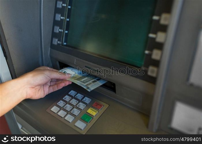finance, money, bank and people concept - close up of hand withdrawing cash at atm machine