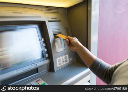 finance, money, bank and people concept - close up of woman hand inserting card to atm machine