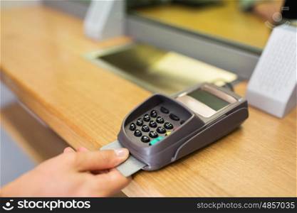 finance, money, technology, payment and people concept - close up of hand inserting bank card to terminal