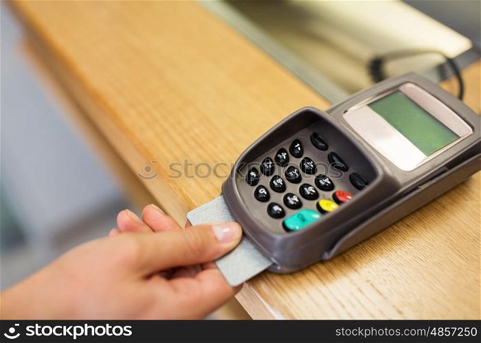 finance, money, technology, payment and people concept - close up of hand inserting bank card to terminal