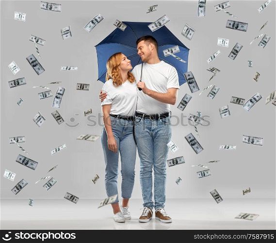 finance, safety and protection concept - happy smiling couple in white t-shirts with umbrella standing under money rain over grey background. happy couple with umbrella standing money rain