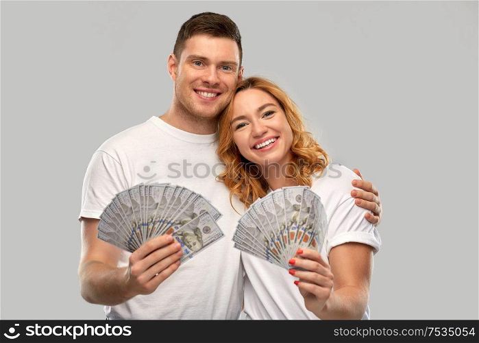 finance, saving and people concept - portrait of happy couple in white t-shirts with euro money over grey background. happy couple in white t-shirts with dollar money