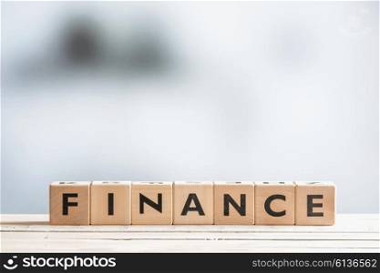 Finance sign on a bright wooden office desk