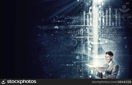 Finances and economics. Young businessman with opened book in hands and light coming out