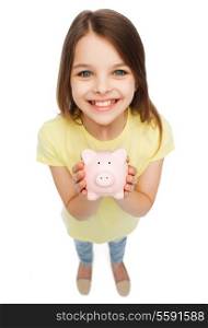 finances, childhood, saving and people concept - beautiful little girl with piggy bank