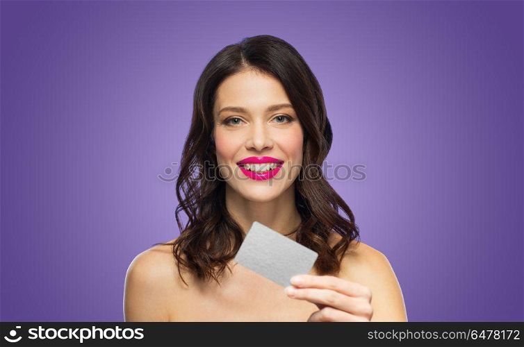 finances, shopping and people concept - happy smiling young woman with pink lipstick holding credit card over ultra violet background. beautiful woman with pink lipstick and credit card. beautiful woman with pink lipstick and credit card