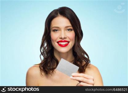 finances, shopping and people concept - happy smiling young woman with red lipstick holding credit card over blue background. beautiful woman with red lipstick and credit card. beautiful woman with red lipstick and credit card