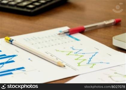 Financial accounting graphs analysis with pen and calculator