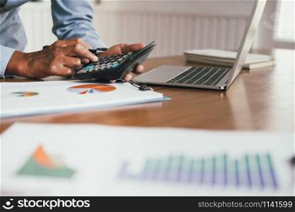 financial adviser working with calculator at office. accountant doing accounting & calculating revenue & budget. bookkeeper making calculation. finance & economy concept
