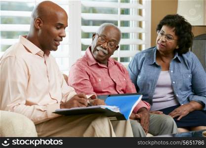 Financial Advisor Talking To Senior Couple At Home