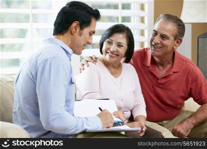 Financial Advisor Talking To Senior Couple At Home