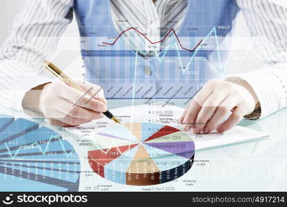 Financial analysis and forecast. Businessman hand writing with pen and digital business infographs