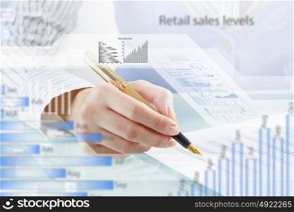 Financial analysis and forecast. Businessman hand writing with pen and digital business infographs