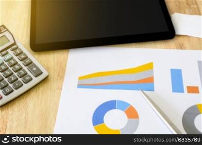financial colorful graph with calculator and tablet, soft light effect