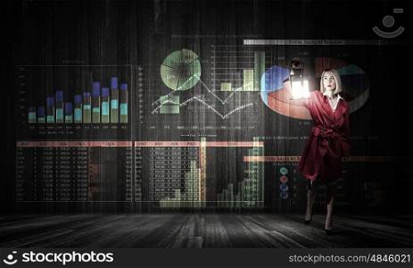 Financial concept with young pretty businesswoman with lantern in darkness. Searching for solution