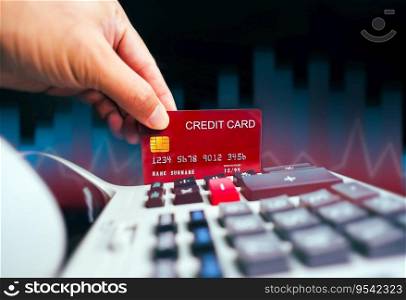 Financial crisis and credit card concept, hand holding red credit card with calculator and blurred business graph in background, Credit Card Debt Crisis and Financial Management.