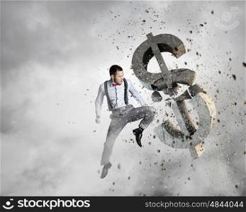Financial crisis concept. Emotional businessman breaking with anger stone dollar symbol