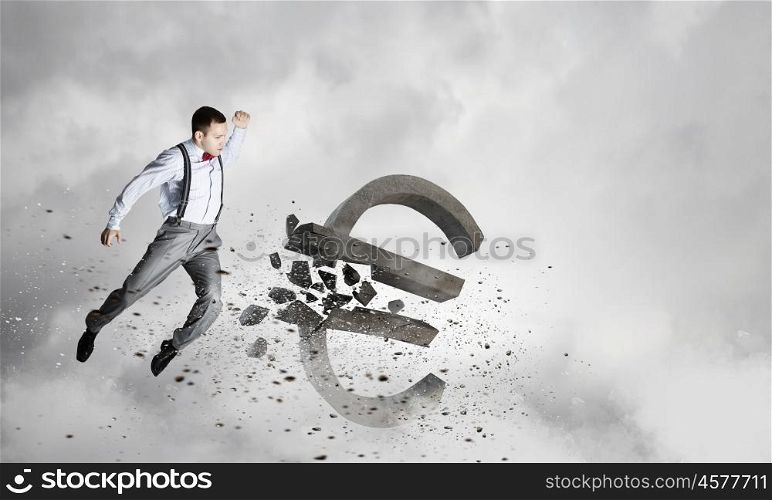 Financial crisis concept. Emotional businessman breaking with hand stone euro symbol