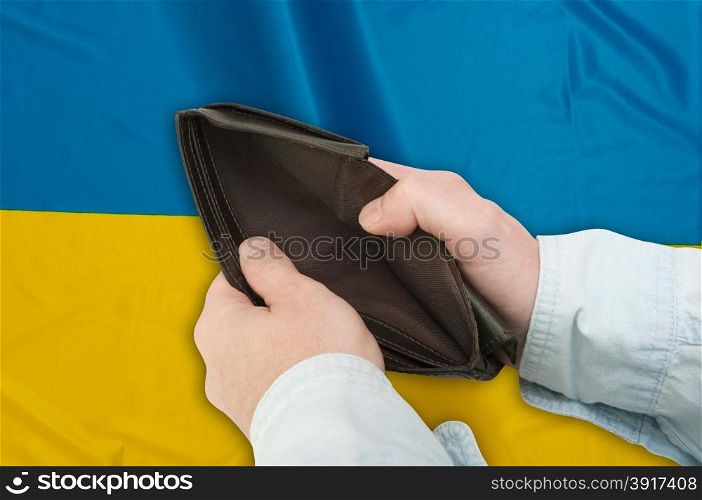 Financial Crisis in Ukraine - Man&rsquo;s Hand With Empty Wallet and Ukrainian flag