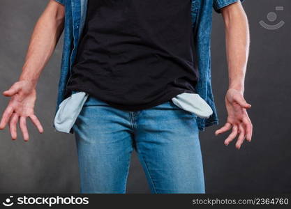 Financial difficulties, bad economy, no money concept. Young man student boy showing empty pockets, part of body male hips wearing jeans pants. Male showing empty pockets