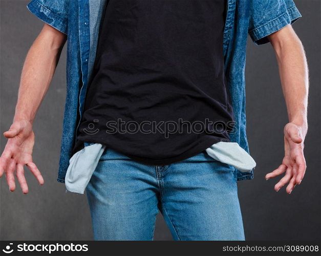 Financial difficulties, bad economy, no money concept. Young man student boy showing empty pockets, part of body male hips wearing jeans pants. Male showing empty pockets