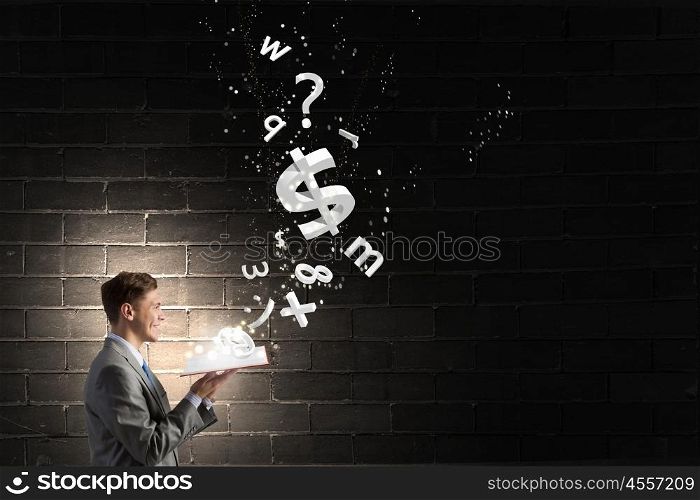 Financial education. Businessman with book and dollar signs flying from pages
