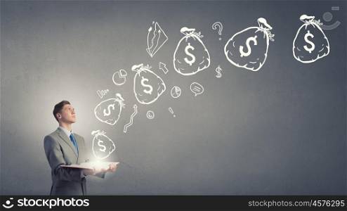 Financial education. Businessman with book and dollar signs flying from pages