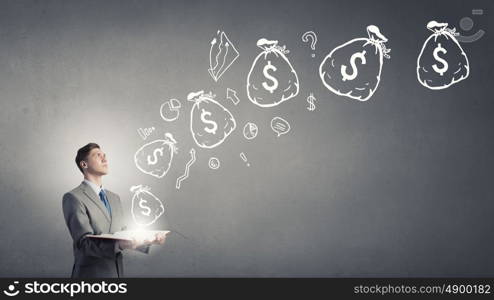 Financial education. Businessman with book and dollar signs flying from pages