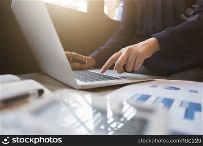 financial executive working on investment data with documents and laptop