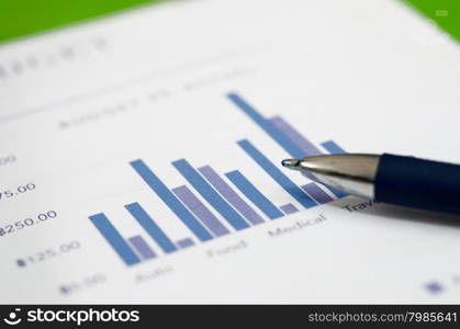 Financial graphs analysis and pen.